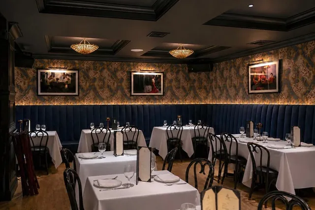 Dinner at Sei Less The dining room at Sei Less — floral wallpaper, navy velvet banquettes and white-linen tables under gold chandeliers in Midtown Manhattan